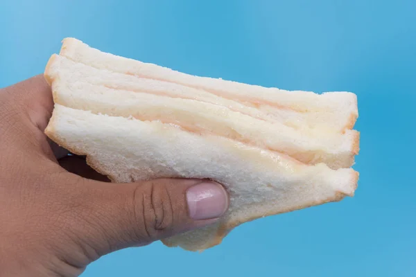 Hand met een stuk ham sandwich — Stockfoto