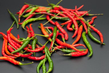 Siyah arkaplanda kırmızı ve yeşil acı biber