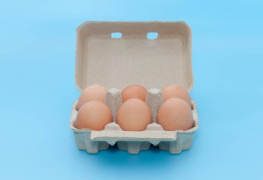 Mavi arka planda karton yumurta tepsisi kutusu
