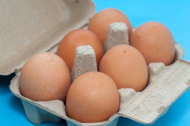 Mavi arka planda karton yumurta tepsisi kutusu