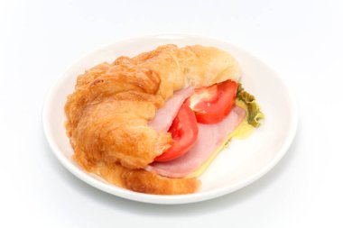 Beyaz tabakta kruvasan jambon ve peynir.