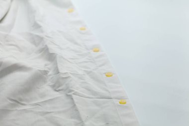 Kirli gömleğin üzerindeki eski düğmeyi kapat.