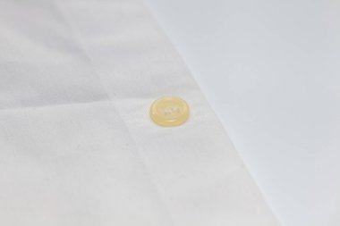 Kirli gömleğin üzerindeki eski düğmeyi kapat.