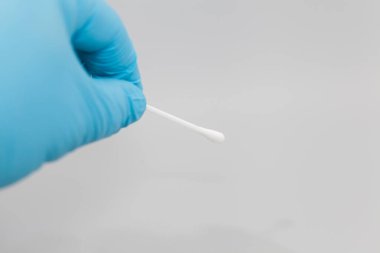 Mavi eldiven ve pamuklu cımbız.