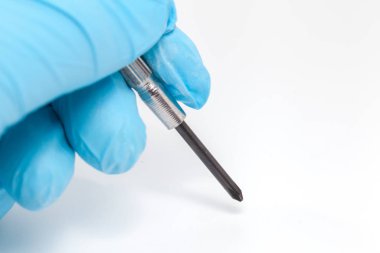 hand in blue glove holding Electronic screwdriver