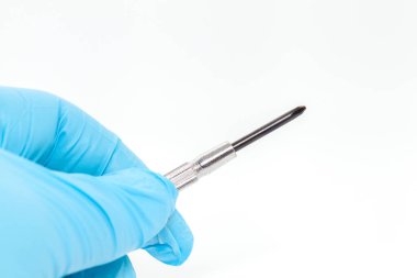 hand in blue glove holding Electronic screwdriver