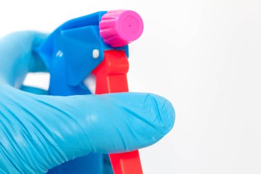 hand in blue glove holding spray bottle