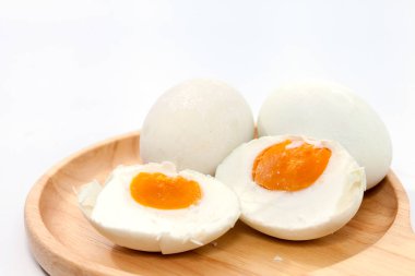 close up of salted egg on wooden plate