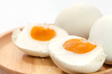 close up of salted egg on wooden plate