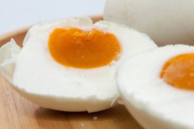 close up of salted egg on wooden plate