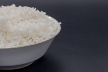 cooked rice on bowl on black background