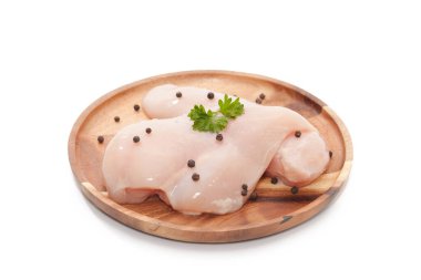 Raw chicken breast,peppers and parsley on wooden plate