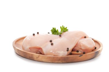 Raw chicken breast,peppers and parsley on wooden plate