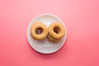 Fried Donuts with sugar topping on pink background