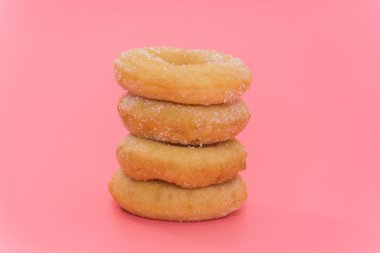 Fried Donuts with sugar topping on pink background