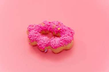 close up of colorful doughnut on pink background