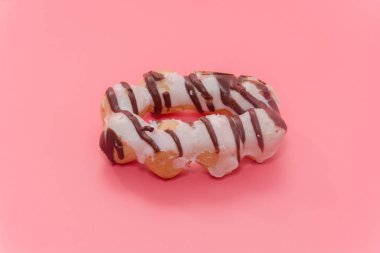 close up of colorful doughnut on pink background