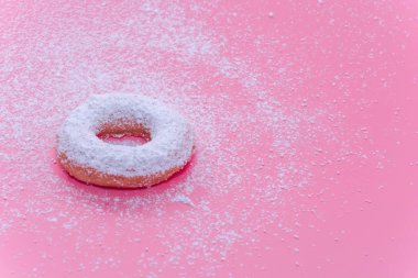Fried Donuts on pink background with Powdered sugar icing
