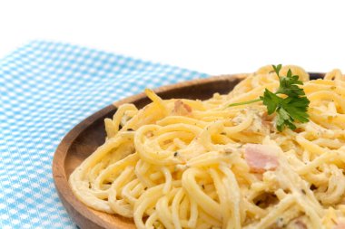 spaghetti carbonara with cream on wooden plate on white backgrou