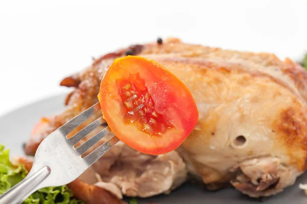 Met tomaat n met vork op witte achtergrond — Stockfoto