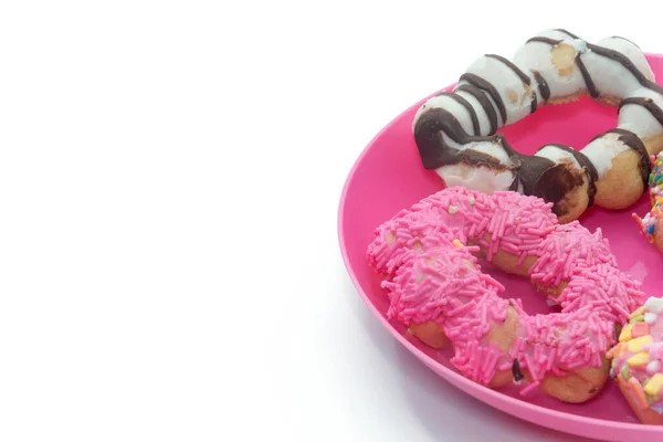 Close up of colorful doughnut on pink plate — Stok fotoğraf