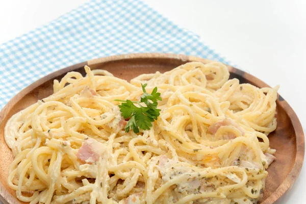 Спагетти карбонара со сливками на деревянной тарелке на белой спинке — стоковое фото