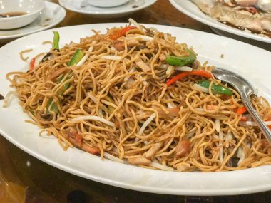 close up of fried egg noodle with roasted pork