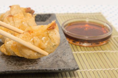 Siyah tabakta kızarmış domuz eti köftesi.