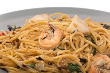 Beyaz arka planda yalıtılmış deniz mahsullü spagetti.