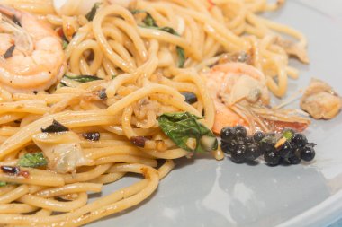 Beyaz arka planda yalıtılmış deniz mahsullü spagetti.