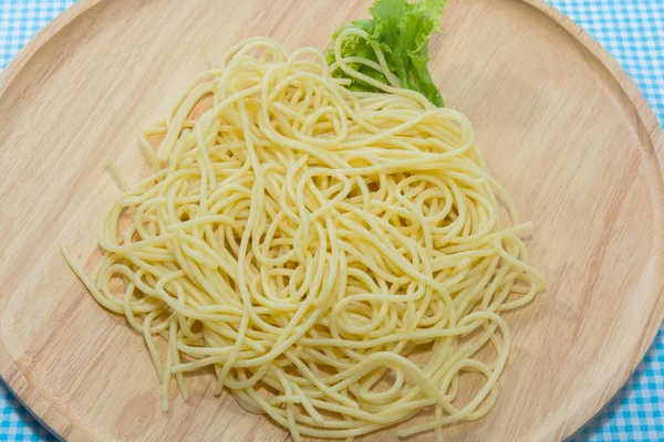 Perto de espaguete sem molho na chapa de madeira — Fotografia de Stock