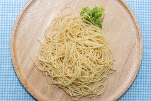 Spaghetti bez sosu z widelcem na drewnianym talerzu — Zdjęcie stockowe