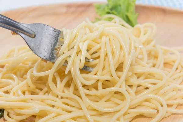 Spaghetti sans sauce avec fourchette sur assiette en bois — Photo