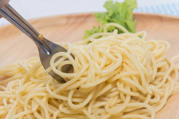 Spaghetti sans sauce avec fourchette sur assiette en bois — Photo