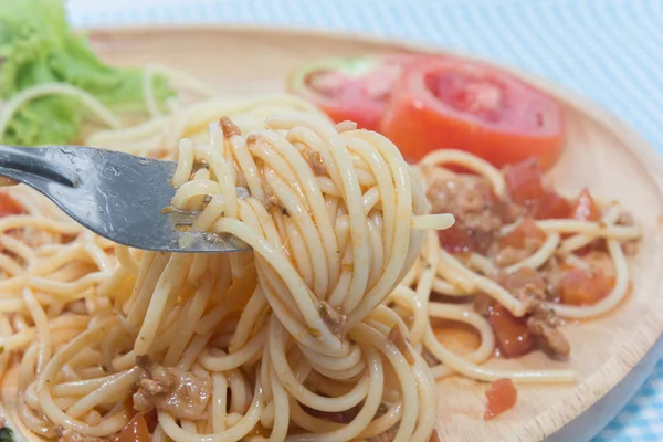 Закрыть спагетти с соусом и вилкой — стоковое фото