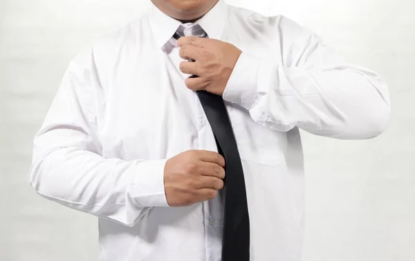Businessman in white shirt taking off neck tie — Stock Photo, Image