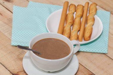 salted bread stick and cup of coffee