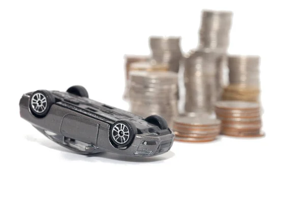Incidente di auto giocattolo e pila di monete isolate su backgrou bianco — Foto Stock