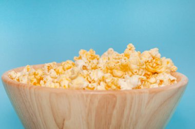 Mavi arka planda patlamış mısırın ahşap kaplamasını kapat