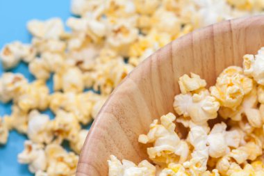 Mavi arka planda patlamış mısırın ahşap kaplamasını kapat