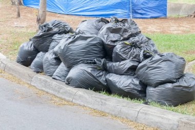 Parkta siyah çöp torbası yığını