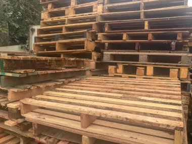 Bir depoya istiflenmiş ahşap paletleri kapatın.