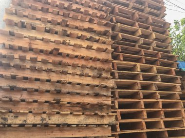 Bir depoya istiflenmiş ahşap paletleri kapatın.