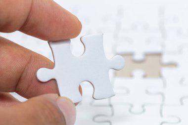 Beyaz jigsaw puzzle parçası tutan el