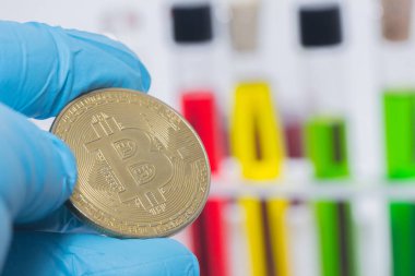 Test tüpünde sıvı ile el ele tutuşan bitcoin