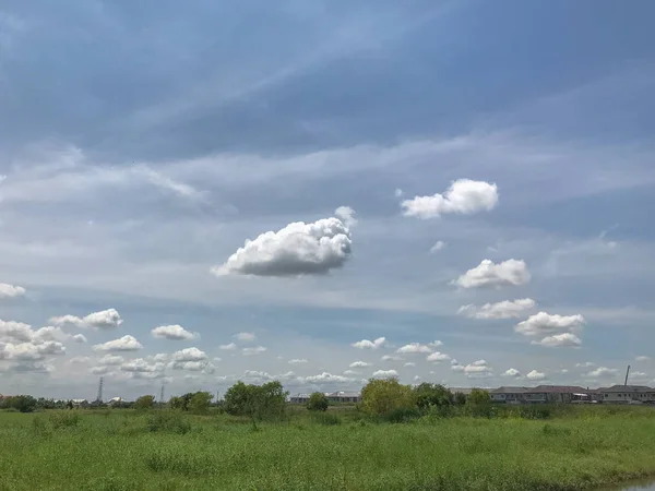 Beautiful thick fluffy clouds and grass field — 스톡 사진