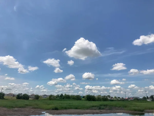 Beautiful thick fluffy clouds and grass field — 스톡 사진