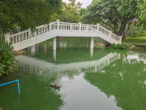 Hermoso puente de hormigón cruzar el estanque — Foto de Stock