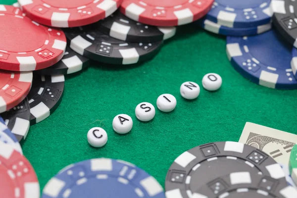 Słowo "kasyno" z żetonów i pieniędzy, koncepcja hazardu — Zdjęcie stockowe