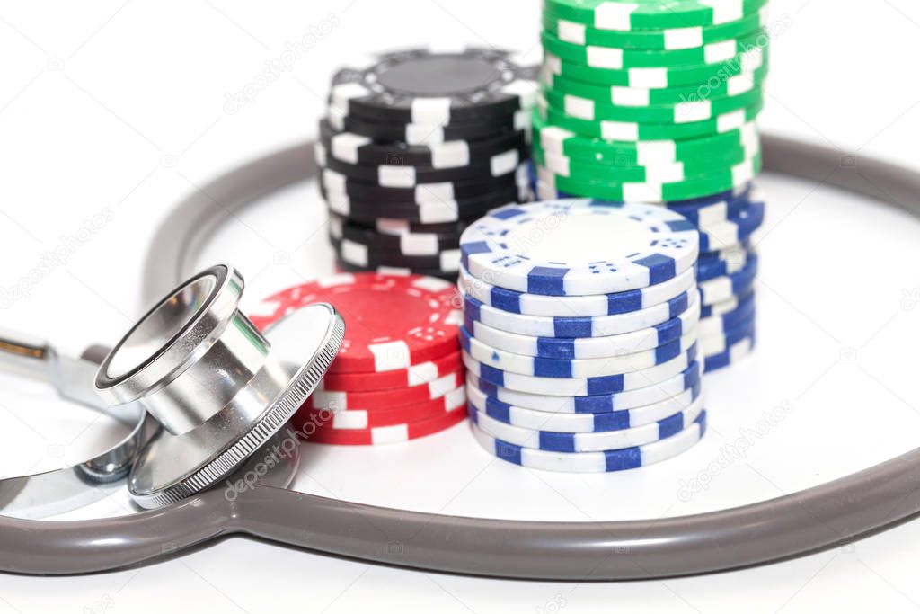 stethoscope and pile of casino chips on white background